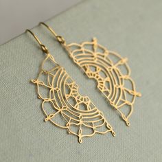 These gold earrings feature a bohemian filigree lace design in solid brass.  The beautiful, intricate detail reminds us of vintage lace and has been hand designed in our Edinburgh studio.   The ear wires are gold plated brass, and the length of these earrings is 40mm, with the lace semi circles designed to hang just below the earlobe.   This piece of handmade jewellery comes packaged in a nice recycled gift box with a handmade tag, all ready to give or keep. 🖤 FASTER SHIPPING 🖤 Need this fast? Yellow Gold Brass Plug Earrings, Brass Filigree Dangle Hoop Earrings, Gold Brass Plug Earrings With Intricate Design, Bohemian Gold Chandelier Earrings For Festival, Bohemian Gold Plug Earrings With Intricate Design, Brass Filigree Dangle Plug Earrings, Brass Drop Earrings With Intricate Design, Gold Teardrop Brass Plug Earrings, Intricate Design Brass Drop Earrings