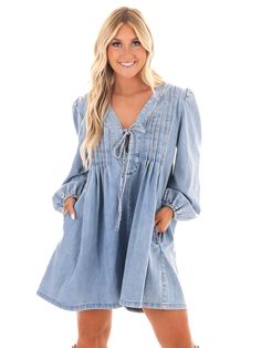 Unleash your inner denim diva with our Blue Jean Beauty Denim Romper! This playful romper features a pleated front with a trendy tie detail, along with convenient pockets for all your essentials. And with a deep v-neckline, you'll be turning heads wherever you go. Time to rock that denim look in style! Spring Cotton V-neck Denim Jumpsuit, Trendy V-neck Denim Jumpsuit For Spring, Trendy V-neck Denim Dress For Day Out, Spring V-neck Cotton Denim Jumpsuit, Casual V-neck Denim Jumpsuit With Pockets, Denim V-neck Dress With Pockets, Spring V-neck Denim Jumpsuit With Pockets, Chic Denim V-neck Dress With Pockets, Chic V-neck Denim Dress With Pockets