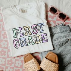 FREE SHIPPING ON ORDERS $75+ WITH CODE "FREESHIP75" Celebrate your love for teaching first graders with this charming "First Grade" t-shirt! Featuring a cute collegiate font layered with elegant script text, this design perfectly blends classic and whimsical styles. Made from soft, high-quality fabric, it's comfortable enough for everyday wear in the classroom. Show off your first-grade pride or gift it to your favorite teacher for a stylish and heartfelt touch! First Grade Teacher Shirt Comfort Collegiate Font, Third Grade Teacher Shirts, Third Grade Teacher, 2nd Grade Teacher, Second Grade Teacher, December 24th, First Grade Teachers, Teacher Appreciation Gift, Whimsical Fashion