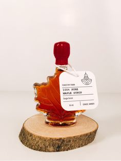 a bottle of maple syrup sitting on top of a piece of wood with a price tag