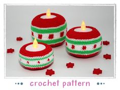 three red and green knitted candle holders with lit candles