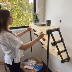 a woman standing in front of a desk with a laptop on it