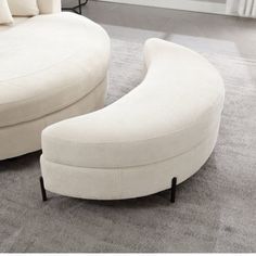 a large white couch sitting on top of a carpeted floor next to a chair