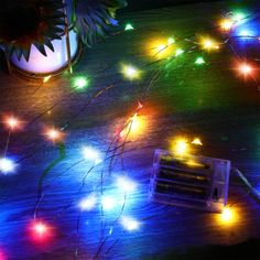 an array of multicolored lights on a wooden table next to a small radio