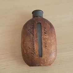 an old bottle with writing on it sitting on a table