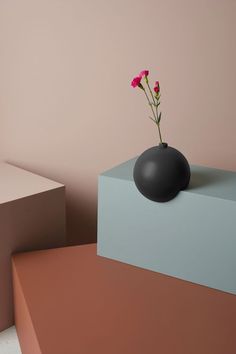 two vases with flowers in them sitting on top of each other near one another