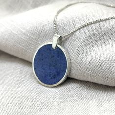 Dumortierite in a sterling silver pendant setting. This design features an elegant backless sterling silver setting. No matter how the piece rests on the body, the stone can always be viewed. This purchase includes a 45cm sterling silver curb chain. Other options are available upon request. Silver Lapis Lazuli Round Pendant Necklace, Silver Necklace With Round Lapis Lazuli Pendant, Blue Oval Pendant Necklace With Polished Finish, Sapphire Sterling Silver Oval Pendant Necklace, Circle Pendant, Curb Chain, Sterling Silver Pendant, Always Be, Sterling Silver Pendants