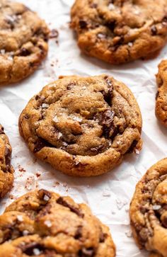 several chocolate chip cookies on top of white paper