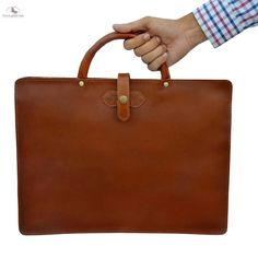 a hand holding a brown leather briefcase on top of a white background with the handle extended