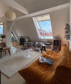 a living room filled with lots of furniture next to a tall window covered in skylights