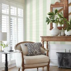 a living room filled with furniture and a mirror on top of a wooden table next to a window