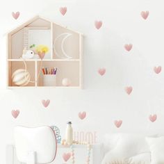 a room with pink hearts on the wall and a shelf in the corner that holds books