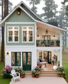 a house that is sitting in the grass next to some plants and flowers on the ground