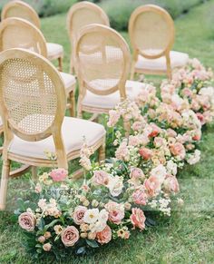 rows of chairs lined up in the grass with pink and white flowers on each row