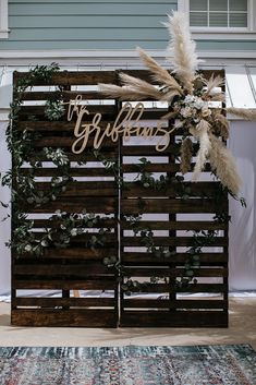 a wooden sign that says the bride and groom on it with some plants in front of it