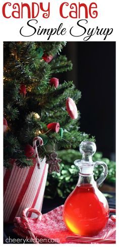 a bottle of candy cane syrup sitting next to a christmas tree with the words candy cane simple syrup on it