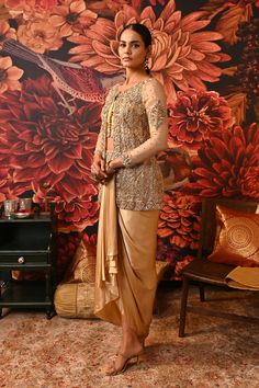 This Gold Co-ord set is the way to hop on the bold and versatile trend, that modern women prefer. Paired with a waistcoat style top along with a heavily embroidered jacket detailed with silver and golden hue and for the bottom a dhoti-style draped skirt giving you that chic regal look. Gold foil printed sleeveless blouse with embroidered border and handmade buttons on the centre front Front Open jacket with gold foil print heavily embellished with dabka & nakshi Waistcoat style bustier Dhoti-sty Elegant Brocade Pre-draped Saree For Diwali, Elegant Festive Brocade Pre-draped Saree, Gold Brocade Pre-draped Saree With Zari Work, Gold Pre-draped Saree For Reception, Elegant Brocade Pre-draped Saree For Designer Wear, Gold Pre-draped Saree With Resham Embroidery For Evening, Formal Festive Pre-draped Saree With Intricate Embroidery, Semi-stitched Sets With Gold Embroidery And Traditional Drape, Festive Palazzo Set With Intricate Embroidery For Party Wear