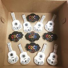 a cardboard box filled with decorated cookies in the shape of guitars