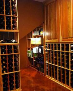 a wine cellar filled with lots of bottles and wooden shelves next to a wall mounted wine rack