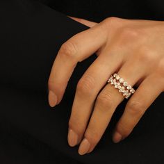 a woman's hand wearing a ring with three small flowers on the middle of it