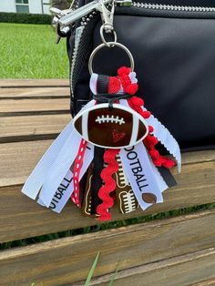 a keychain with a football on it sitting on top of a wooden bench