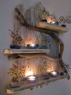 two wooden shelves with candles on them and some branches hanging from the wall next to each other