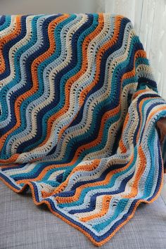 a crocheted blanket sitting on top of a couch