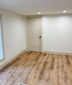 an empty room with hard wood floors and white walls