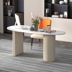 a modern dining table with an orange chair in the center and bookshelves behind it