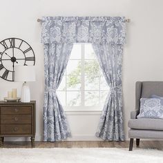 a living room with a chair, clock and window