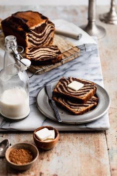 slices of chocolate marbled bread on plates with butter and cinnamon in small bowls next to them