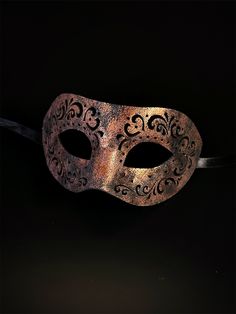 Crafted with intricate engraved patterns on soft vegan leather, this mask is a masterpiece of artistry that adds an air of mystique to your masquerade ensemble. Embrace the allure of engraved elegance and captivate hearts with your enigmatic presence at masquerades and special events! Age Group/Gender - Adult/Men Size/Type - One size fits all adults Mask Color - Copper Mask Material - Vegan Leather Nature Masquerade Mask, Venetian Formal Eye Mask, Elegant Eye Mask For Theater, Formal Venetian Eye Mask For Masquerade, Elegant Theater Eye Mask, Venetian Style Formal Eye Masquerade Mask, Vintage Eye Mask For Parties, Vintage Eye Mask For Party, Vintage Masquerade Eye Mask