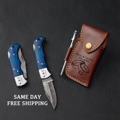 two knives and a wallet sitting next to each other on a black surface with the words same day free shipping