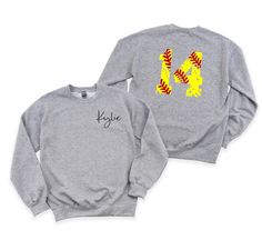 Step up your style game with our personalized crewneck sweatshirt! Our custom crewneck sweatshirt comes with a pocket sized name   on the front - you choose first name, last name, club name! But that's not all - the customization doesn't stop there. We've also added a softball number on the back, giving this sweatshirt a personalized and fashionable edge. Stay cozy, make a statement, and showcase your individuality with our one-of-a-kind crewneck sweatshirt. If you like your sweatshirts loose or oversized, you might want to order a size up and if you'd like a more fitted look then order a size down. WE RECOMMEND MEASURING YOUR FAVORITE FITTING SWEATSHIRT AND COMPARING TO THE MEASUREMENTS ON THE SIZE CHART. **Ships with in 5-10 business days** Every tee is handmade to order with love. Pleas Baseball Season Crew Neck Sweatshirt With School Spirit, School Spirit Sweatshirt With Crew Neck For Baseball Season, School Spirit Crew Neck Sweatshirt For Baseball Season, Crew Neck Sweatshirt For Baseball Season With School Spirit, Customizable Sweatshirt For Streetwear And Sports Season, Gray Long Sleeve Team Name Sweatshirt, Customizable Crew Neck Sweatshirt For Game Day, Customizable Long Sleeve Sweatshirt For Sports Season, Customizable Long Sleeve Sweatshirt For Game Day