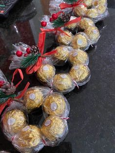 chocolates wrapped in cellophane and tied with red ribbon are lined up on a table