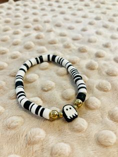 Enjoy this beautiful black and white hand-crafted bracelet with clay beads and a white ghost central charm.. Bracelet is elastic banded and stretches to fit an average size female wrist. Celebrate fall and Halloween with this fun jewelry. White Beaded Bracelets For Halloween Gift, White Beaded Bracelets For Halloween, Handmade White Beaded Bracelets For Halloween, White Beaded Novelty Stretch Bracelet, White Novelty Beaded Stretch Bracelet, White Adjustable Jewelry For Halloween, Adjustable White Jewelry For Halloween, Handmade White Beaded Novelty Bracelets, Handmade White Novelty Beaded Bracelets