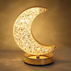 a golden moon shaped lamp on a stand