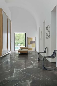 an elegant living room with marble flooring and white walls, along with modern furniture