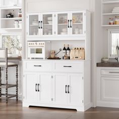 a kitchen with white cabinets and countertops in the middle of it, along with a dining room table