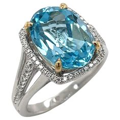 This stunning cocktail ring features a beautiful 8.59 carat oval blue topaz set in a gorgeous 18k gold mounting. The sparkling Swiss blue topaz has been set with 18k yellow gold prongs which not only highlight the center stone but provide lovely contrast and allow this ring to be paired with both white and yellow gold jewelry! Brilliant white diamonds form a halo around the center stone creating an elegant outline, with more diamonds continuing along the center of the split "triple" band. Beauti Yellow Gold Jewelry, Ring Pendant Necklace, Swiss Blue Topaz, Diamond Halo, White Ring, White Diamonds, Round Brilliant Cut Diamond, Cocktail Ring, Cocktail Rings