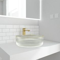 a bathroom sink sitting on top of a white counter next to a mirror and tiled walls