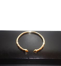 This listing is for a really beautiful 18K gold filled West Indian bangle. This bangle is designed with a beautiful intricate style carving and have arrow heads. It is adjustable and look great on the wrist. This bangle weigh 25.6g, is adjustable fits a 6-8 inch wrist. Make this a great gift or treat yourself!! Buyer lands a great deal and will not be disappointed.