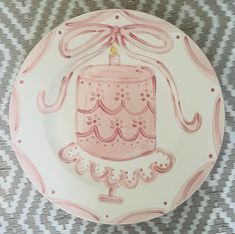 a pink birthday cake plate with a candle on it