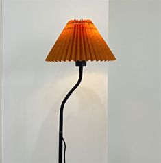 a lamp that is on top of a white table next to a wall and floor