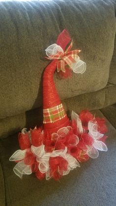 a red hat sitting on top of a couch next to a pile of tulle