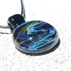 The handblown amazing Glass Galaxy Pendant is made with borosilicate glass. Each pendant is handmade and totally unique, like a piece of art, and each one is made with lots of care. Inside this pendant, there's something really cool, it's pure silver fuming mixed with pure gold fuming. When these metals are heated, they create beautiful colors on the glass. It's like magic! The colors change from white to different shades of blue with the touch of gold, making it look like a galaxy. The background of this handcrafted pendant is dark-colored, like the night sky, which makes the colors stand out even more. And there are little shiny bits on the pendant that look like stars that sparkle in the sun, adding to its beauty. When you get the pendant, it comes in a nice white box, ready to give to Galaxy Pendant, Heady Glass, Gift For Her Birthday, Touch Of Gold, White Box, Artisan Craft, Pure Gold, Glass Pendant, Glass Jewelry