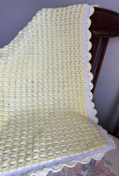 a crocheted blanket sitting on top of a wooden chair