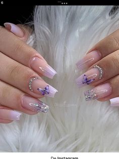 a woman's hands with pink and white nail polishes on her nails, holding a