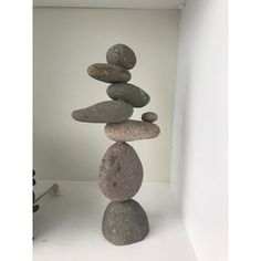 several rocks stacked on top of each other in a white room with a wall behind them