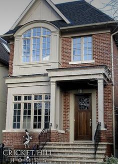 a brick house with white trim and two story entryway leading up to the front door